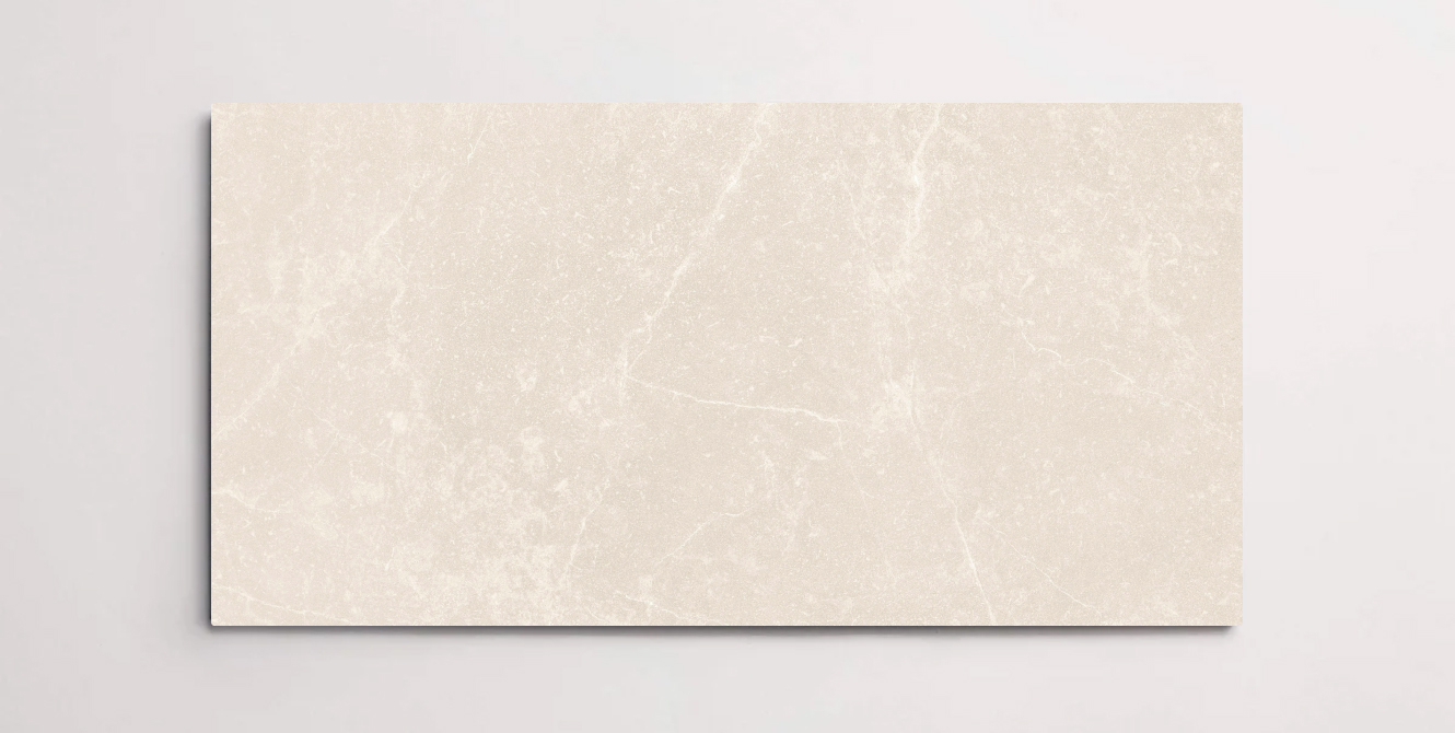 A single cream colored 10" x 30" stone-like porcelain tile with subtle veining